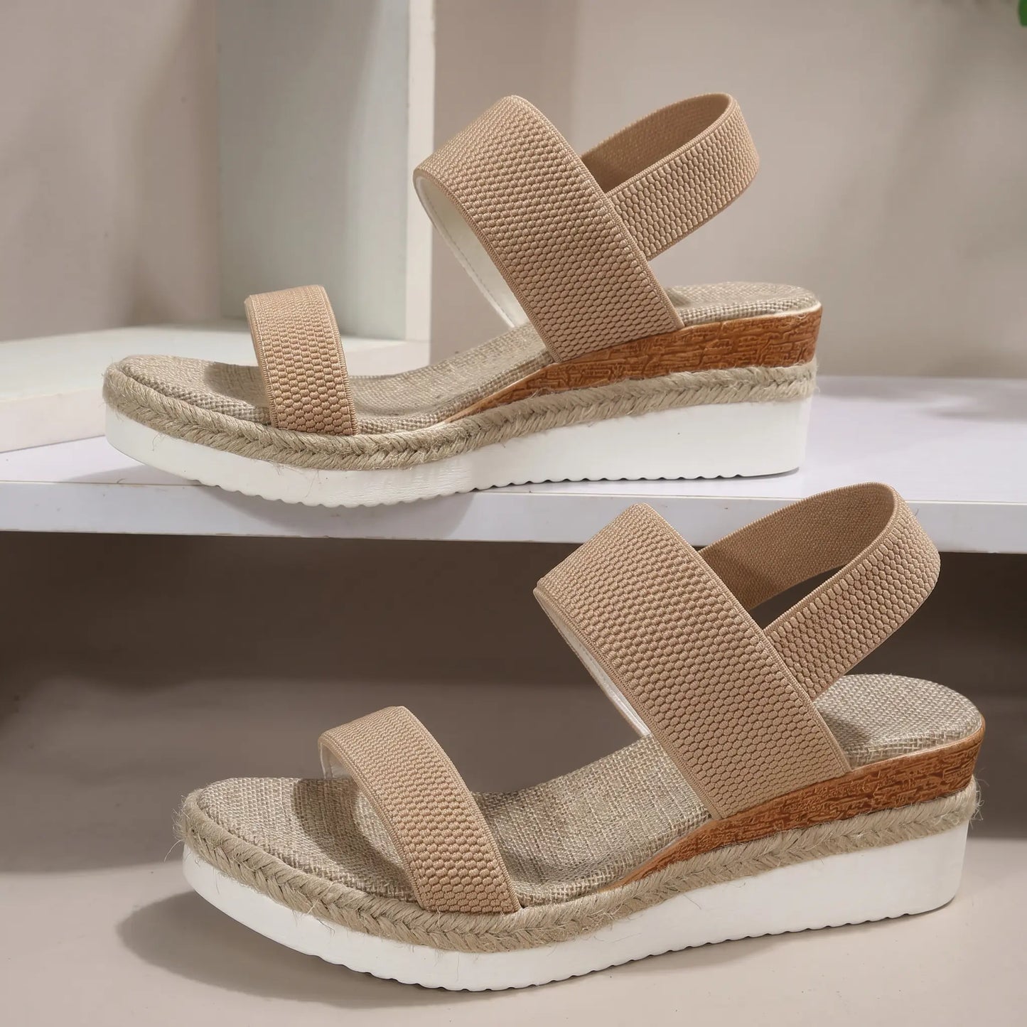 A pair of beige woven fabric Zirath espadrille wedge sandals shown from a three-quarter angle on a shelf.