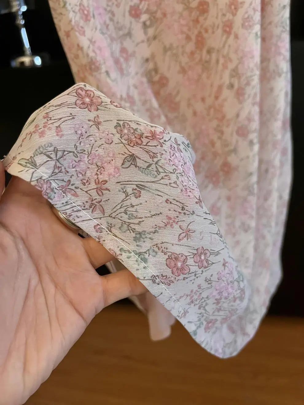 Close-up of the Zhalis blush floral chiffon maxi skirt, showcasing its delicate ditsy print, semi-sheer texture, and smooth pink lining.