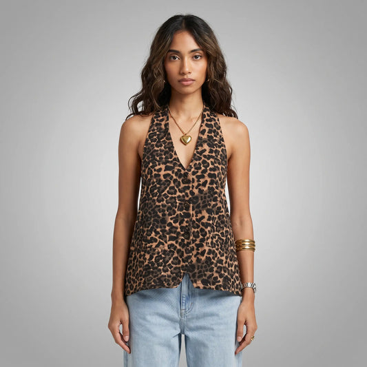Front view of a woman wearing a Kaelen leopard print halter neck top with a deep V-neck and subtle front buttons, paired with light blue jeans.