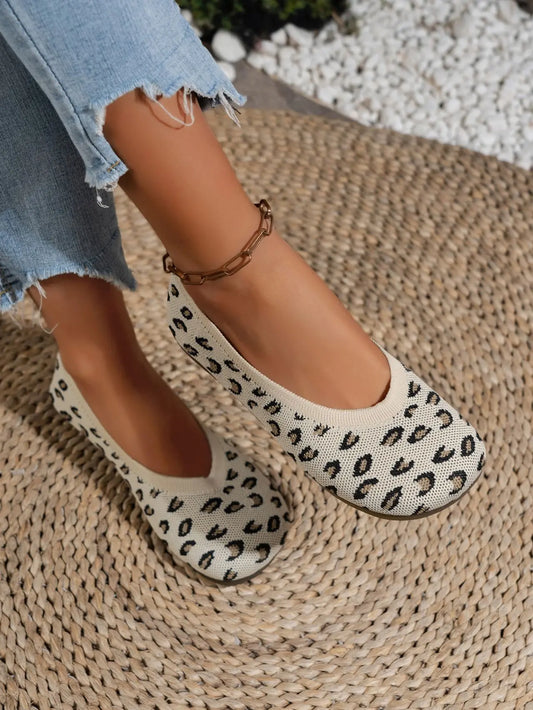 Women's Kaelen knit ballet flats in a leopard print, shown on a person's feet with distressed denim jeans and a gold ankle bracelet.