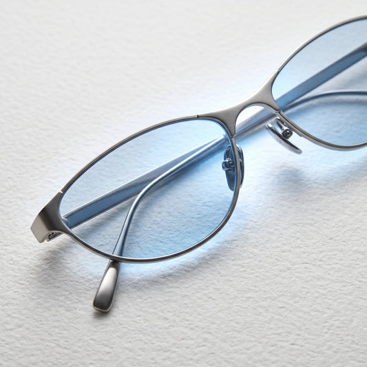 Close-up of Kivago metal cat-eye sunglasses with silver frame and light blue tinted lenses, showcasing the adjustable nose pads and sleek design.