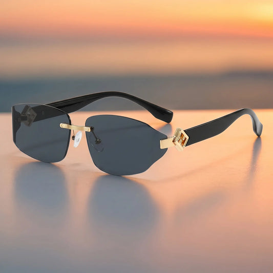 Kyzyl rimless fashion sunglasses with dark gradient lenses, matte black temple arms, and distinctive gold geometric hardware at the temples.