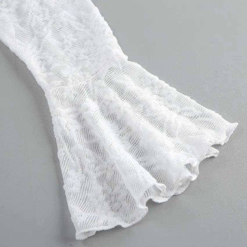 Close-up of a white lace blouse sleeve featuring a delicate floral pattern, voluminous bell shape, and sheer, flowing texture.