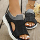 Women's black breathable knit mesh sports sandals with an open toe, layered white sole, and elasticated heel strap, shown on feet styled with distressed denim and an anklet.