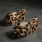 Aerona leopard print wedge sandals featuring an oversized bow detail, peep-toe, and fabric upper, shown from a three-quarter angle on a grey studio background.