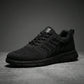 Aerostride men's breathable knit sneakers in black, side view displaying the textured mesh upper and monochromatic EVA sole.