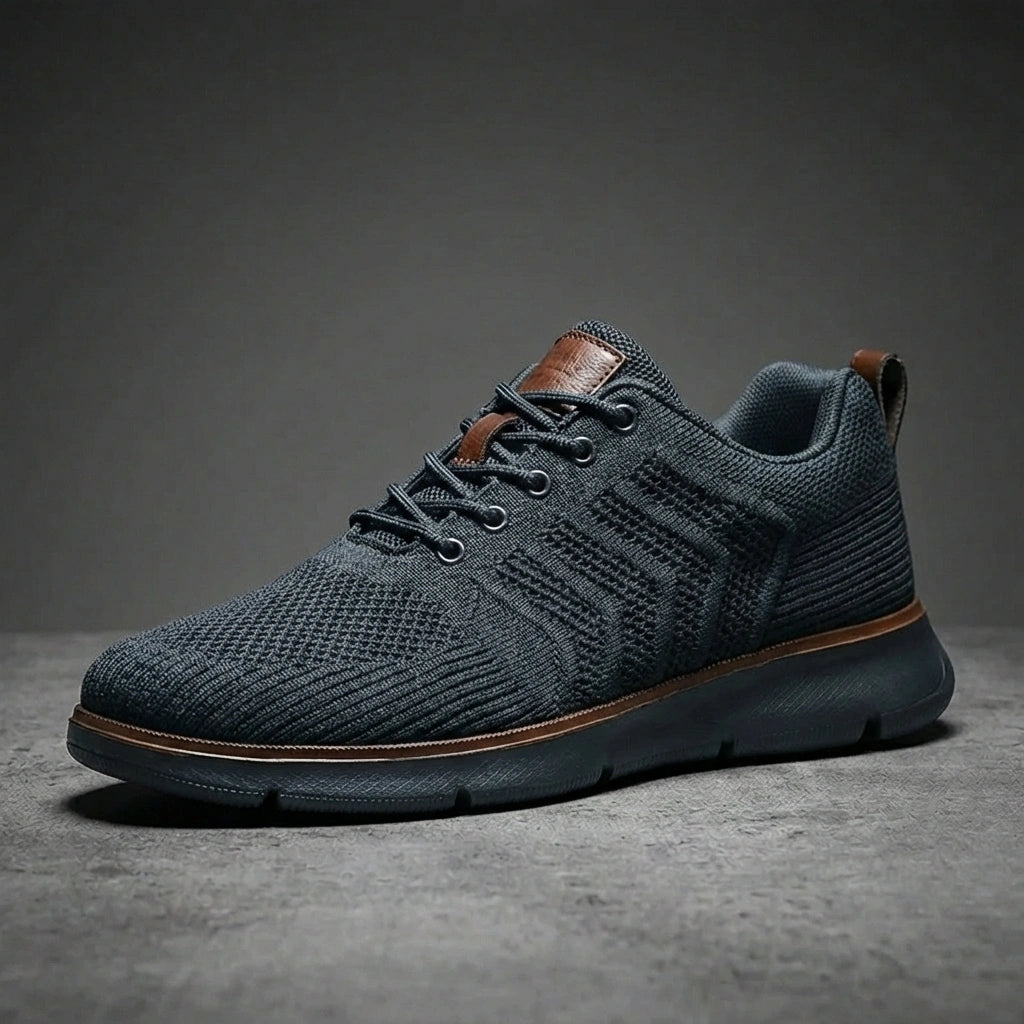 Aerostride Knit Urban Comfort Sneakers in Dark Grey mesh with brown leather accents — side profile view showing the textured upper and cushioned sole.