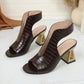 Aethel women's peep-toe block heel sandals in deep chestnut with a woven texture and a striking geometric gold heel, shown from a three-quarter angle.