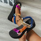 Aethel metallic platform sandals with a chunky 5cm sole worn on a model's feet, showcasing vibrant mixed-media straps in gold, fuchsia, orange, and blue.
