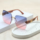 Oversized square sunglasses with pink and blue gradient lenses and brown temples featuring gold 'H' logo accents, displayed in a studio setting.