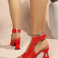Aethel red peep-toe block heel sandals with woven texture and a metallic chain ankle strap, shown on a model's feet from a three-quarter rear view.