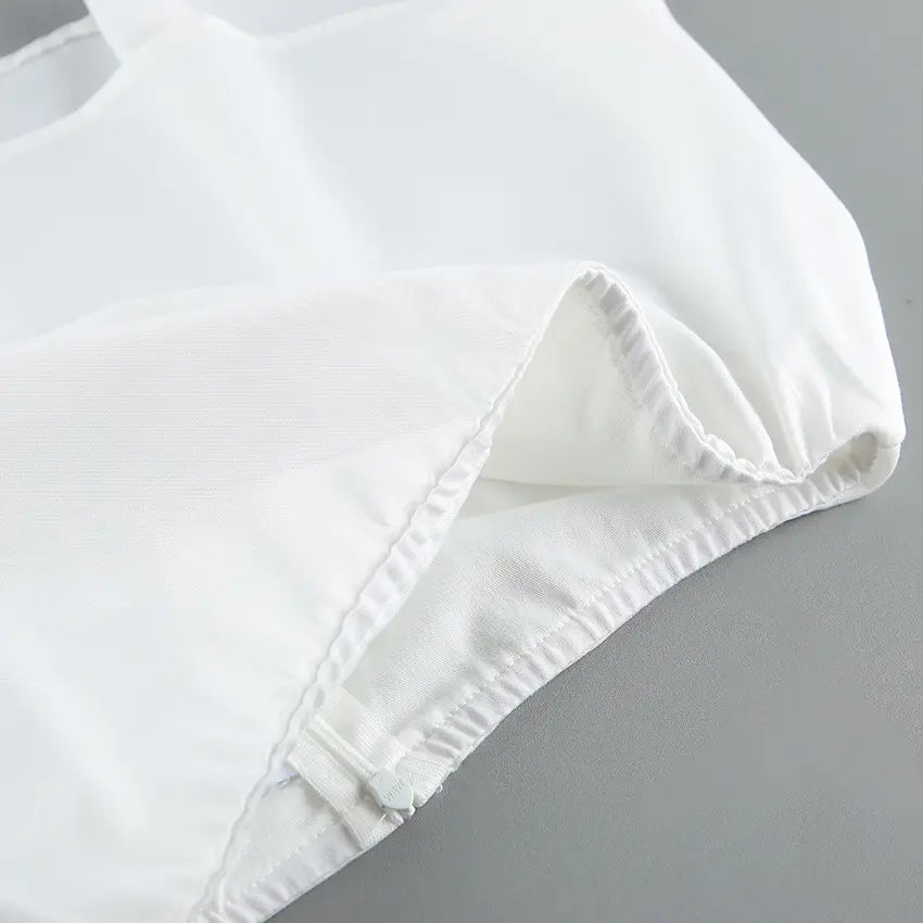 Close-up of white fabric with neat stitching and a visible zipper, showcasing the quality craftsmanship of the Aethel two-piece set.