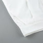 Close-up view of the off-white viscose blend fabric showing fine stitching, crisp pleats, and a side pocket detail on a pair of trousers.