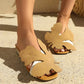 Model wearing Aevana Khaki leaf-embellished bohemian flat slide sandals with crystal-accented heels on a textured outdoor surface.