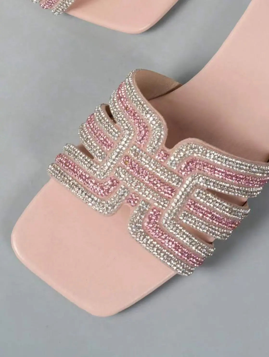 Close-up view of Ayori rhinestone flat slides in blush pink, showcasing intricate embellishments on the single band strap and the square toe silhouette. Subtle padding is visible on the footbed.