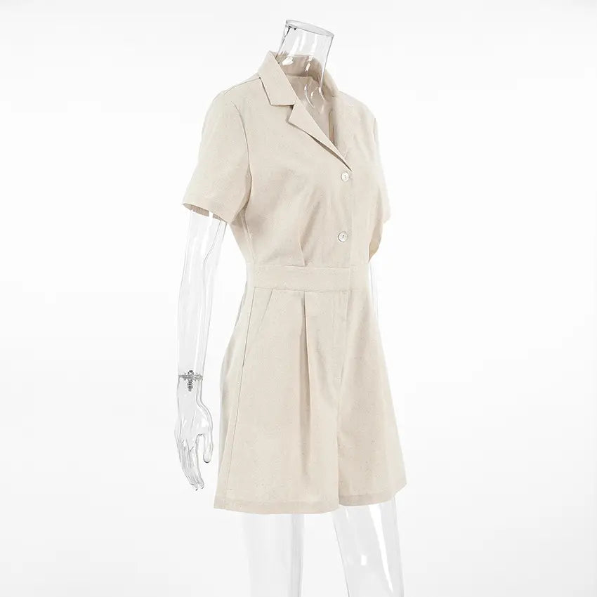 Azkari oat beige linen-blend short-sleeve jumpsuit with camp collar and wide-leg shorts, presented from a side view on a clear mannequin.