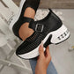 Black women's breathable mesh platform sneakers with a buckle strap and transparent air cushion heel, shown from a three-quarter angle on a foot.