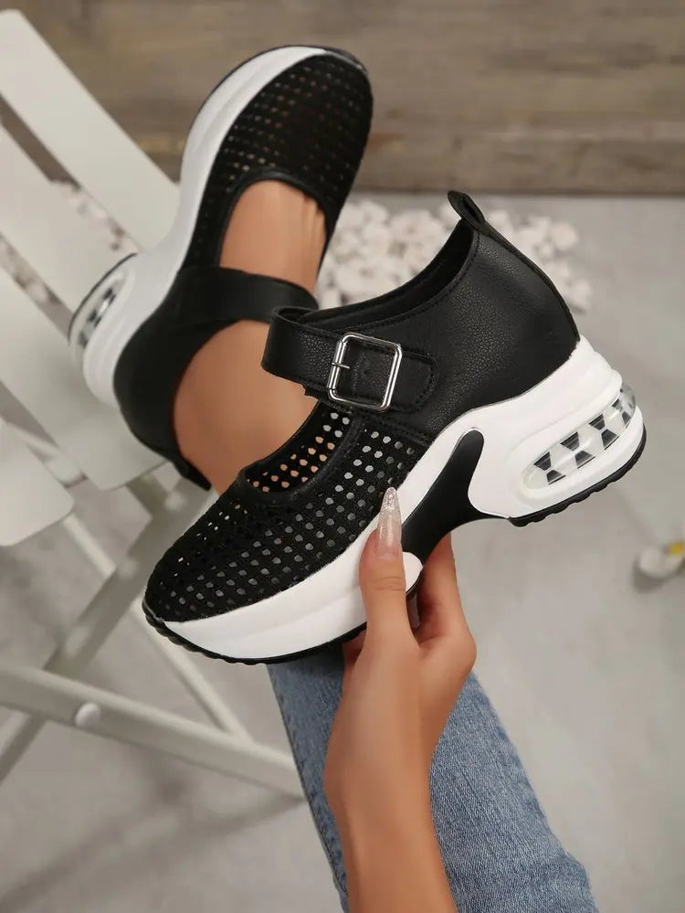 Black women's breathable mesh platform sneakers with a buckle strap and transparent air cushion heel, shown from a three-quarter angle on a foot.
