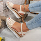 Bohemian beige espadrille wedge sandals with intricate crochet detailing, an adjustable ankle strap, and a jute-wrapped sole, worn with denim.