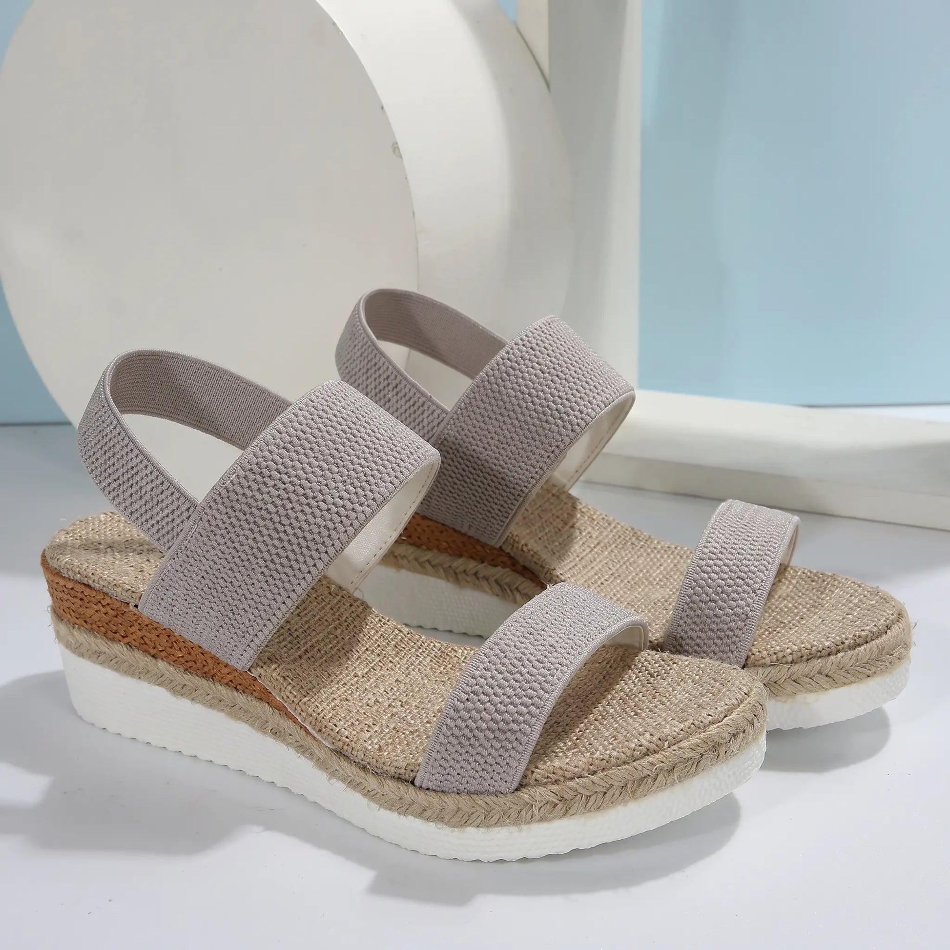 Zirath beige woven fabric espadrille wedge sandals with a natural jute-wrapped sole, substantial platform, and elasticated slingback strap, shown from a three-quarter angle.
