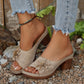 Women's beige peep-toe wedge sandals featuring a layered floral applique and perforated straps, shown on feet with distressed denim.