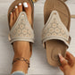 Close-up of women's beige suede-like PU platform thong sandals featuring intricate laser-cut geometric patterns and a gold-tone buckle detail, shown on a foot with an anklet and a hand holding the other sandal. A size 37 indicator is visible on the footbed.