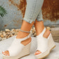 Earthy beige peep-toe espadrille wedge sandals with a jute-wrapped heel and ankle strap, worn with distressed denim jeans.