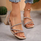 Women's beige slip-on block heel sandals adorned with shimmering rhinestones across delicate multi-straps, featuring a chic square toe.