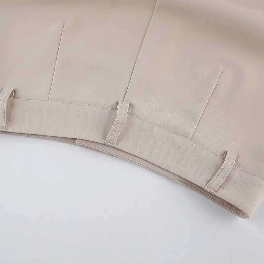 Close-up of warm beige wide-leg palazzo trousers, showcasing the high-waisted design with belt loops and clean stitching.
