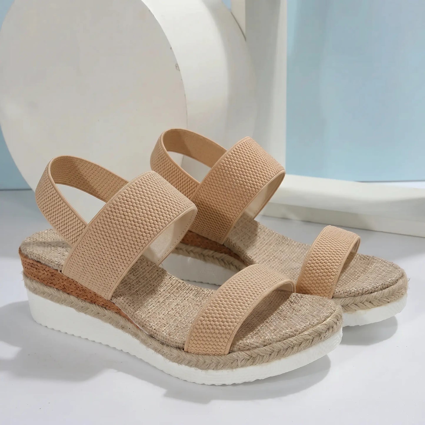 Natural beige woven fabric espadrille wedge sandals with a fish mouth open toe and elasticated slingback strap, showcasing a comfortable mid-height wedge heel and platform sole.