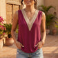 Model wears a berry magenta sleeveless V-neck blouse featuring a wide, contrast beige crochet lace trim. Styled with denim shorts in an outdoor, bohemian-inspired setting.