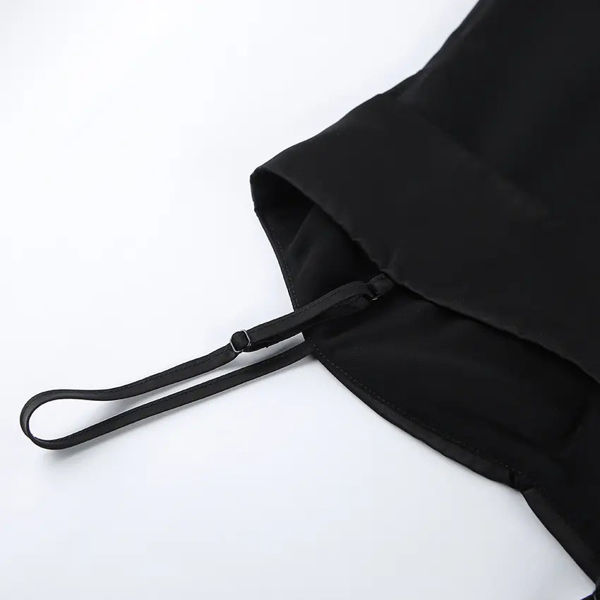 Black camisole detail featuring an adjustable spaghetti strap and the seam where the ruched satin-look bust meets the sheer chiffon lower panel.
