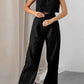 Elegant black linen blend set featuring a sleeveless cropped top and high-waisted wide-leg trousers, modeled in a studio setting for effortless summer style.