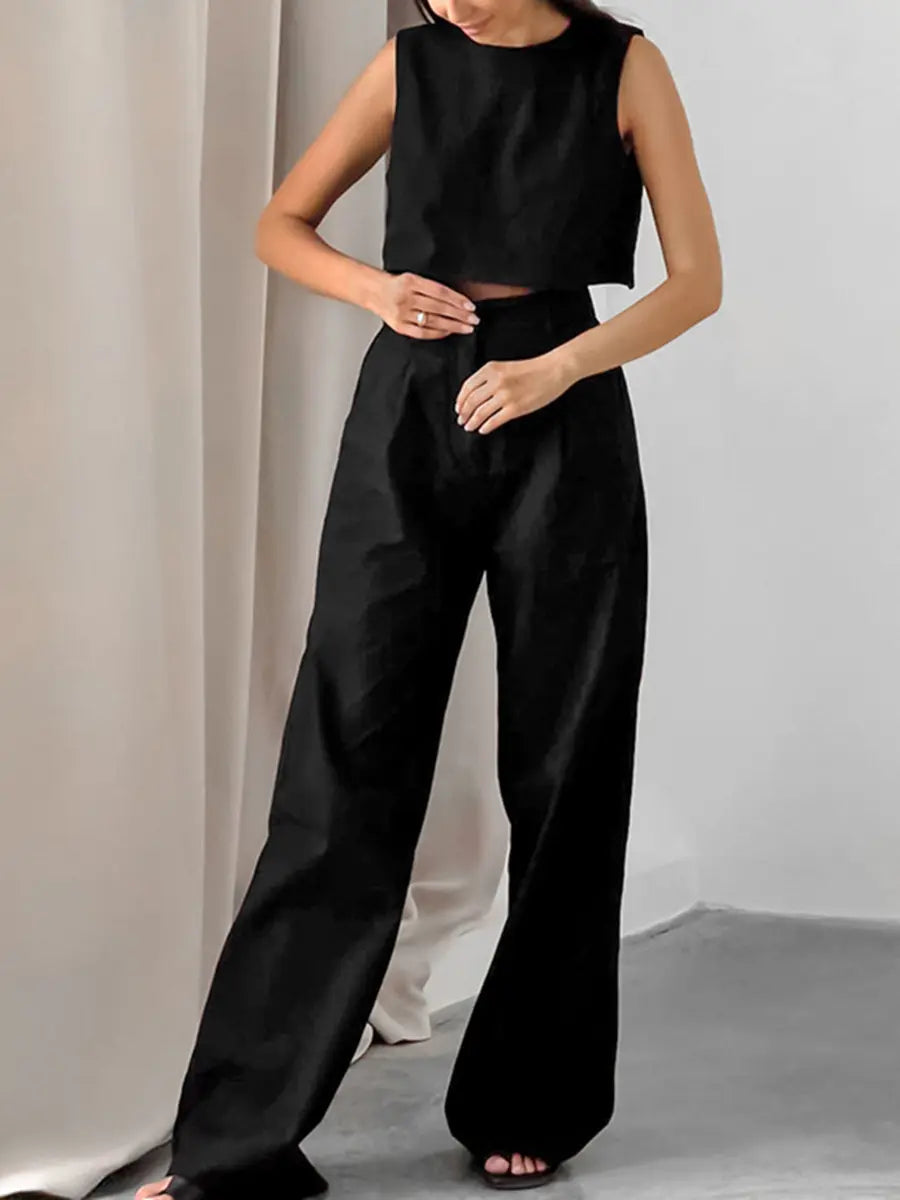 Elegant black linen blend set featuring a sleeveless cropped top and high-waisted wide-leg trousers, modeled in a studio setting for effortless summer style.