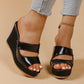 Black peep-toe platform wedge sandals with intersecting straps, featuring a textured snake-effect heel and sole, shown on a model from a three-quarter view.