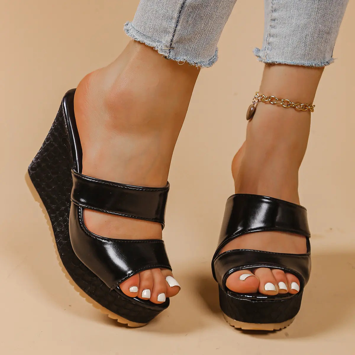 Black peep-toe platform wedge sandals with intersecting straps, featuring a textured snake-effect heel and sole, shown on a model from a three-quarter view.
