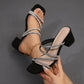 Black square-toe mule sandals with dazzling rhinestone-embellished straps, shown on a foot with a 3-5cm block heel.
