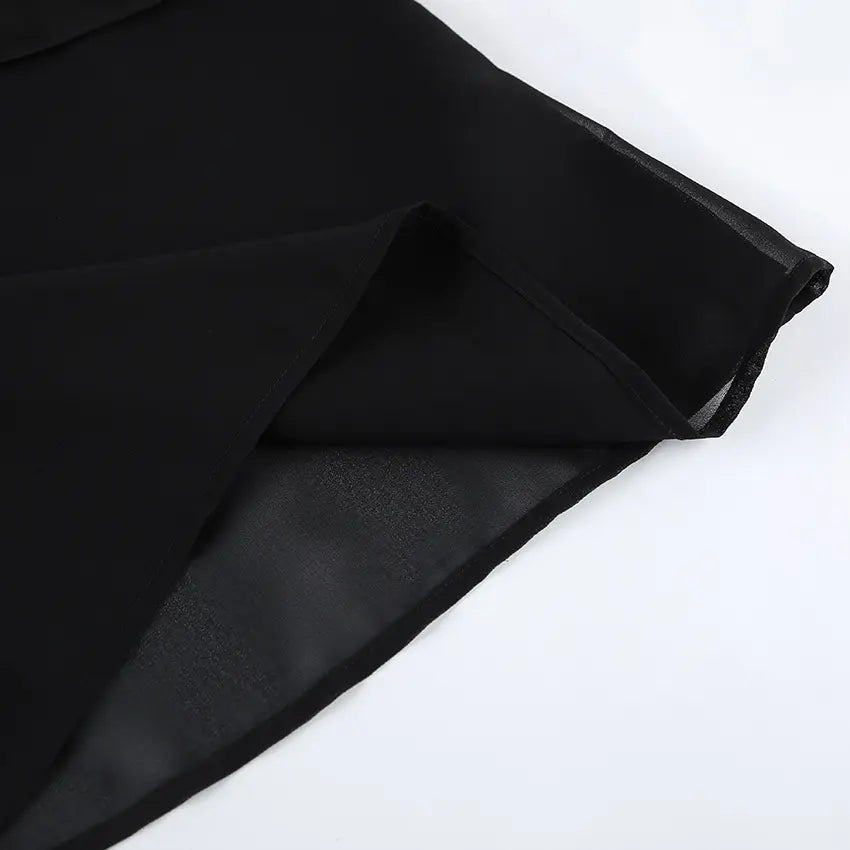 Close-up view of the black sheer chiffon fabric hemline of an elegant top, showcasing its delicate texture and fine weave.