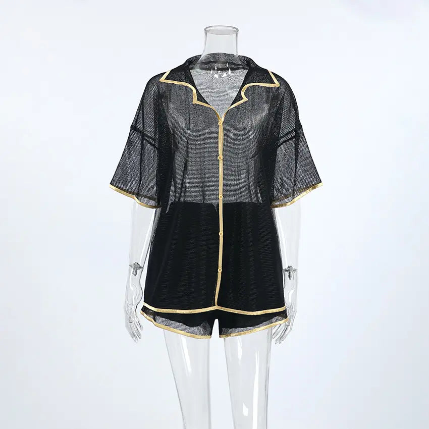 Black sheer mesh lounge set with gold contrast piping, featuring a camp collar button-down shirt and drawstring shorts, displayed on a mannequin against a white background.