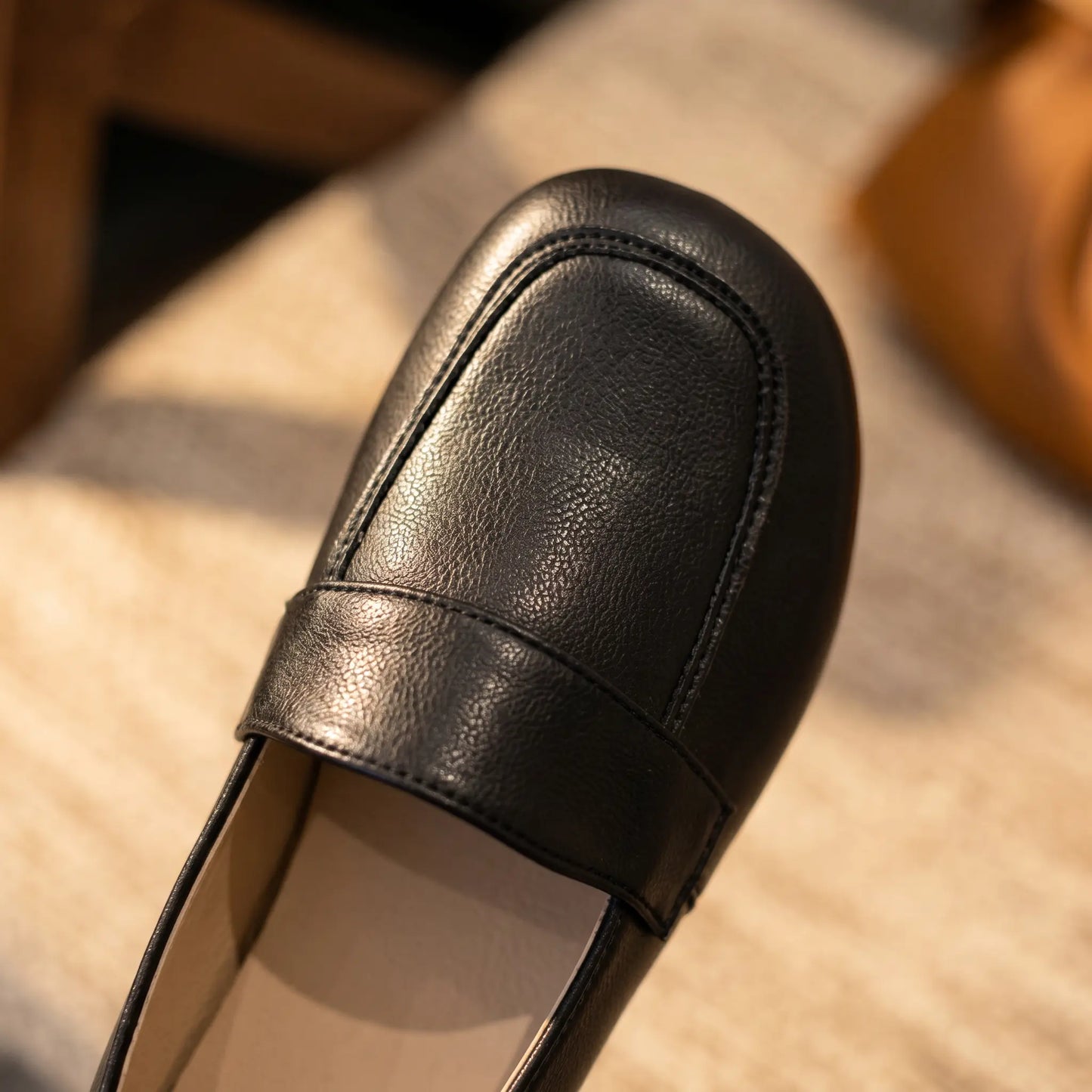 Close-up of a Zoryn Midnight Black vegan leather slip-on loafer, highlighting the soft textured material, rounded toe, and stitched vamp strap detail.