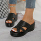 Nexaera black woven platform wedge sandals with a peep-toe design, shown on a person's feet with white-painted toenails.