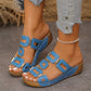 Oceanic blue Kyorin platform wedge sandals with geometric gold-tone embellishments, styled with ripped denim jeans and a pearl anklet on a model's foot.