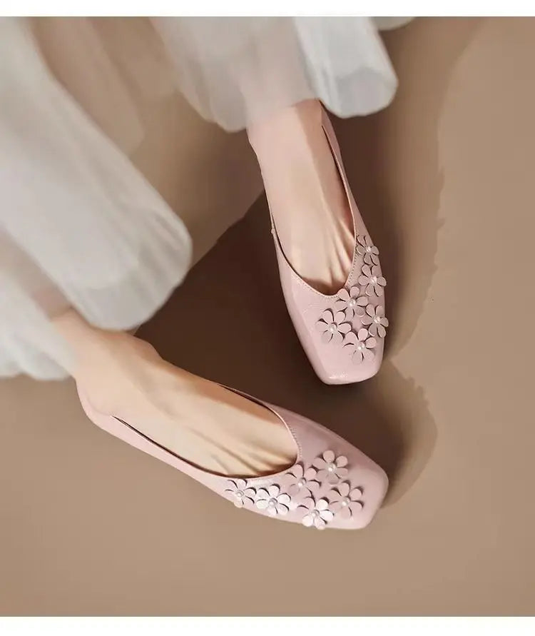 Elegant Blush Rose square toe flats with tonal floral appliques and pearl centers, crafted from vegan leather and gracefully worn.