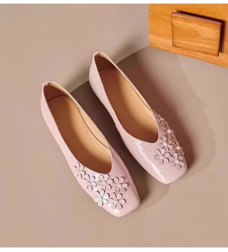 Top-down view of a pair of Blush Rose Khyzet square toe flats, featuring delicate tonal floral appliqués with pearl centers on the vamp.