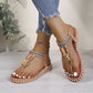 Women's bohemian flat thong sandals featuring intricate floral bead embellishments, woven tribal-patterned straps, and a comfortable elasticated heel strap, worn on feet with distressed jeans on a wooden floor.