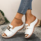 White Brevix women's platform slide sandals featuring a gold-tone metallic buckle and an open-toe design, styled with denim.