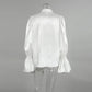 Back view of a white lustrous satin blouse featuring a high stand collar, dramatic ruffled front, and voluminous trumpet sleeves with smocked elasticated cuffs.