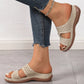 Beige Briska laser-cut wedge sandals worn with distressed blue jeans, showcasing intricate detailing, a cushioned footbed, and low wedge heel for bohemian-inspired comfort.