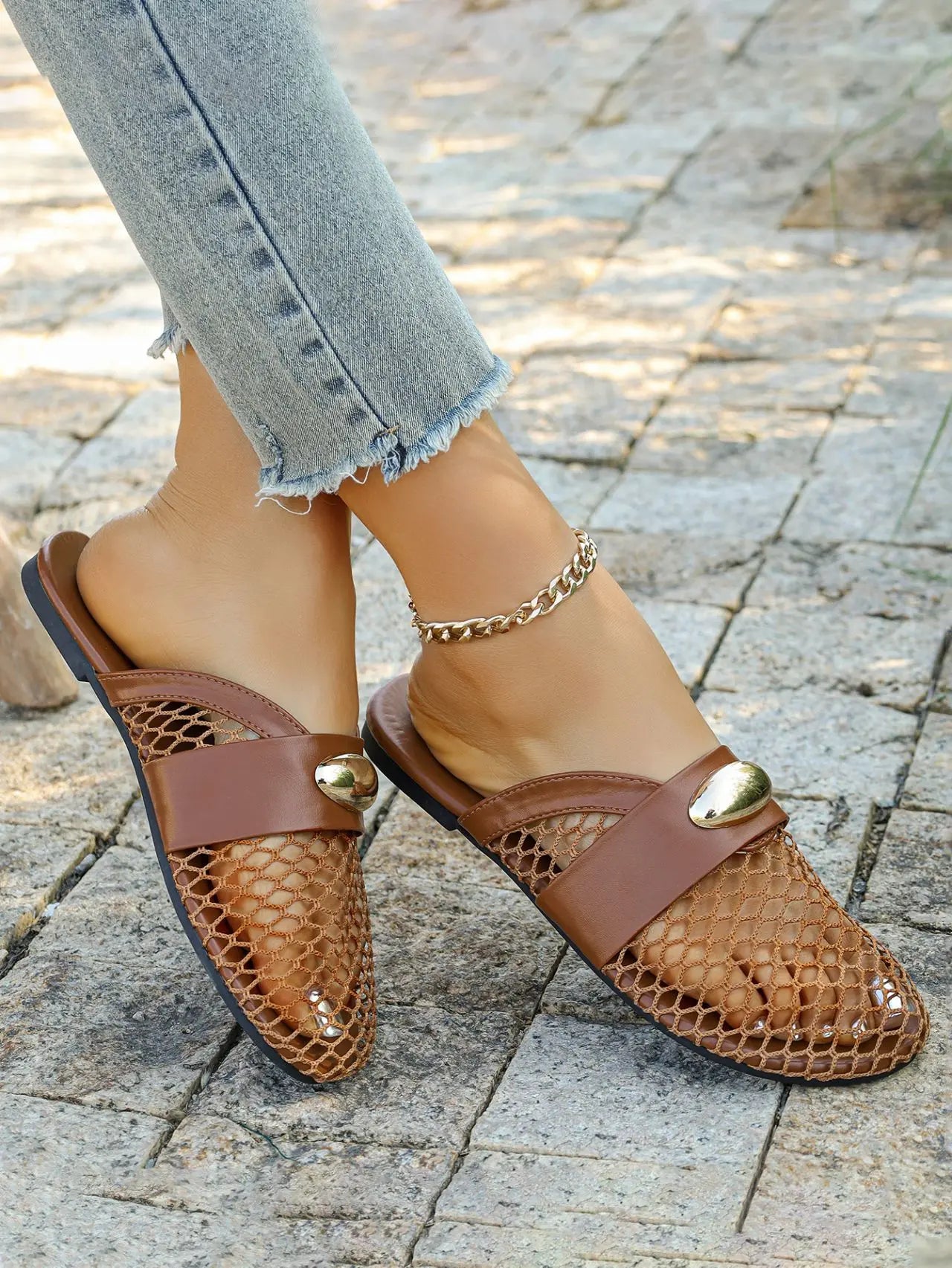 Brown mesh pointed-toe flat mules worn with cropped jeans and a gold anklet, showcasing a chic and breathable summer style with elegant gold hardware.