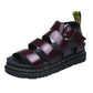 A pair of rich burgundy faux leather gladiator platform sandals with a chunky black sole and yellow stitching detail, shown from a front view.